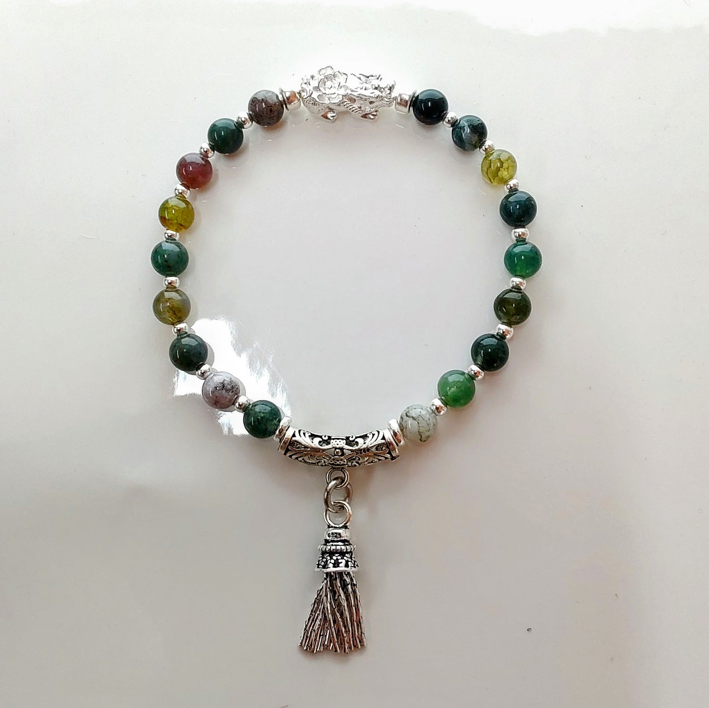 Introducing Sarah Lynn's stunning **Indian Agate Stretch Bracelet**, meticulously handmade with natural Indian agate beads and a pure silver charm featuring an enchanting mythical beast design. Each bead is selected for its unique, earthy colors and patterns, capturing the beauty of nature and spirituality. 