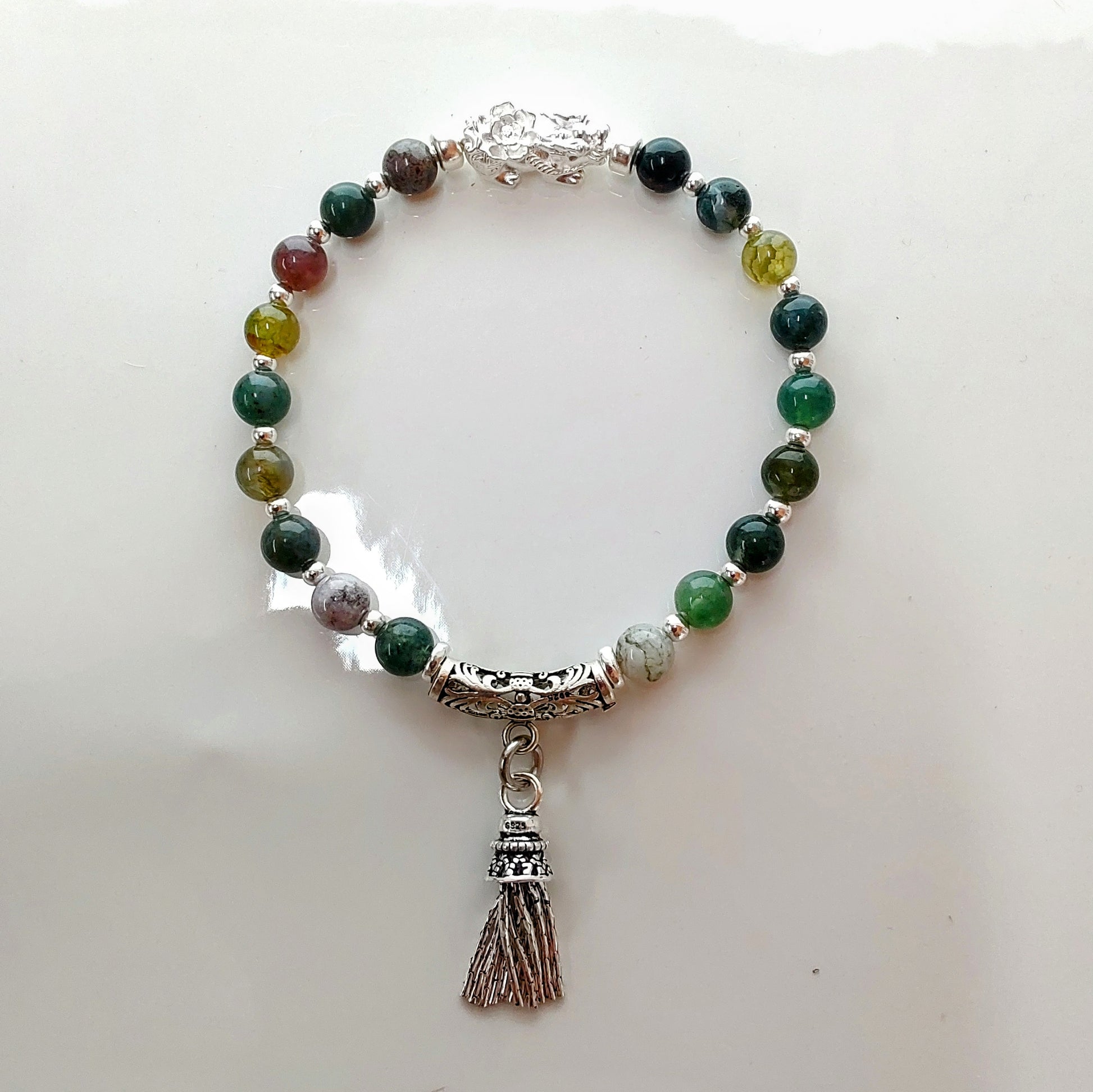 Introducing Sarah Lynn's stunning **Indian Agate Stretch Bracelet**, meticulously handmade with natural Indian agate beads and a pure silver charm featuring an enchanting mythical beast design. Each bead is selected for its unique, earthy colors and patterns, capturing the beauty of nature and spirituality. 