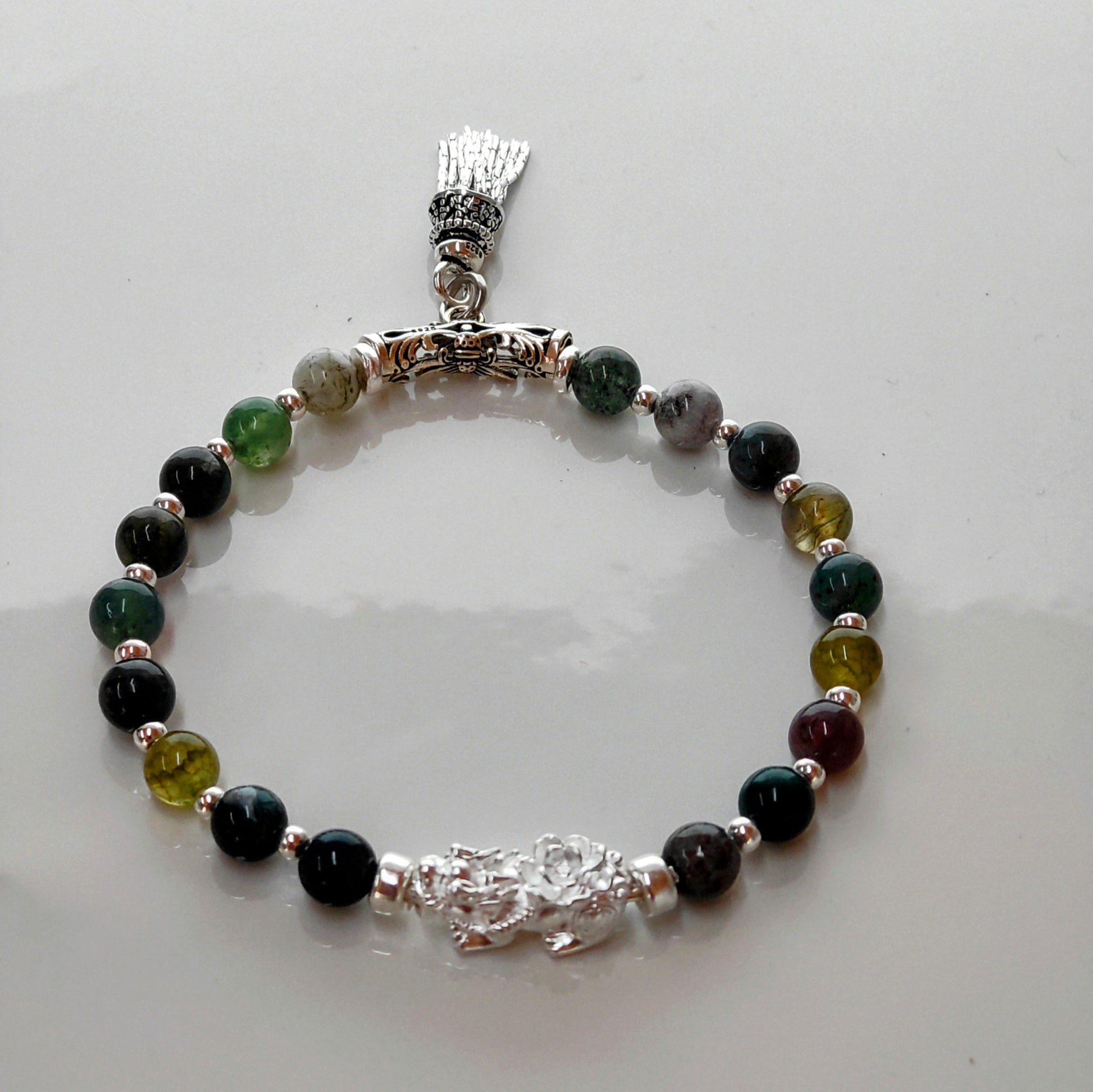 Introducing Sarah Lynn's stunning **Indian Agate Stretch Bracelet**, meticulously handmade with natural Indian agate beads and a pure silver charm featuring an enchanting mythical beast design. Each bead is selected for its unique, earthy colors and patterns, capturing the beauty of nature and spirituality. 